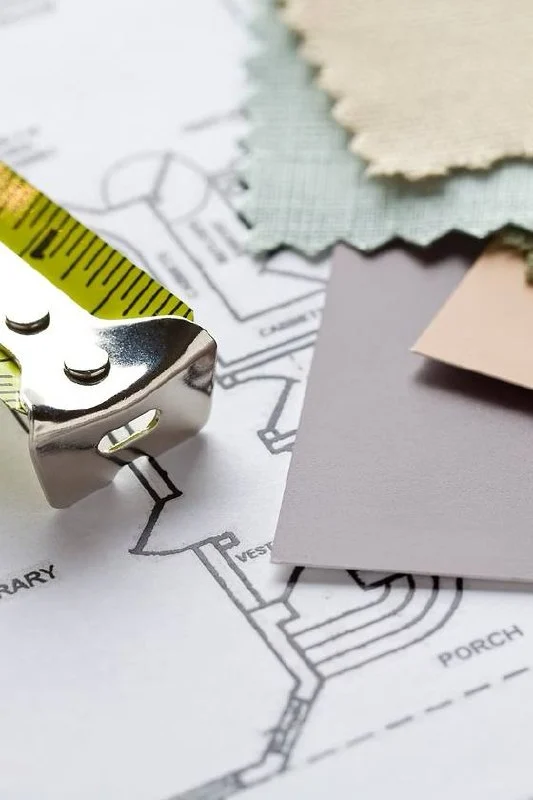 Fabric swatches and a tape measure on a floor plan